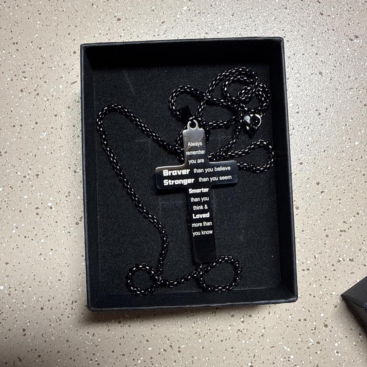 Black cross necklace with white text reading 'Always...