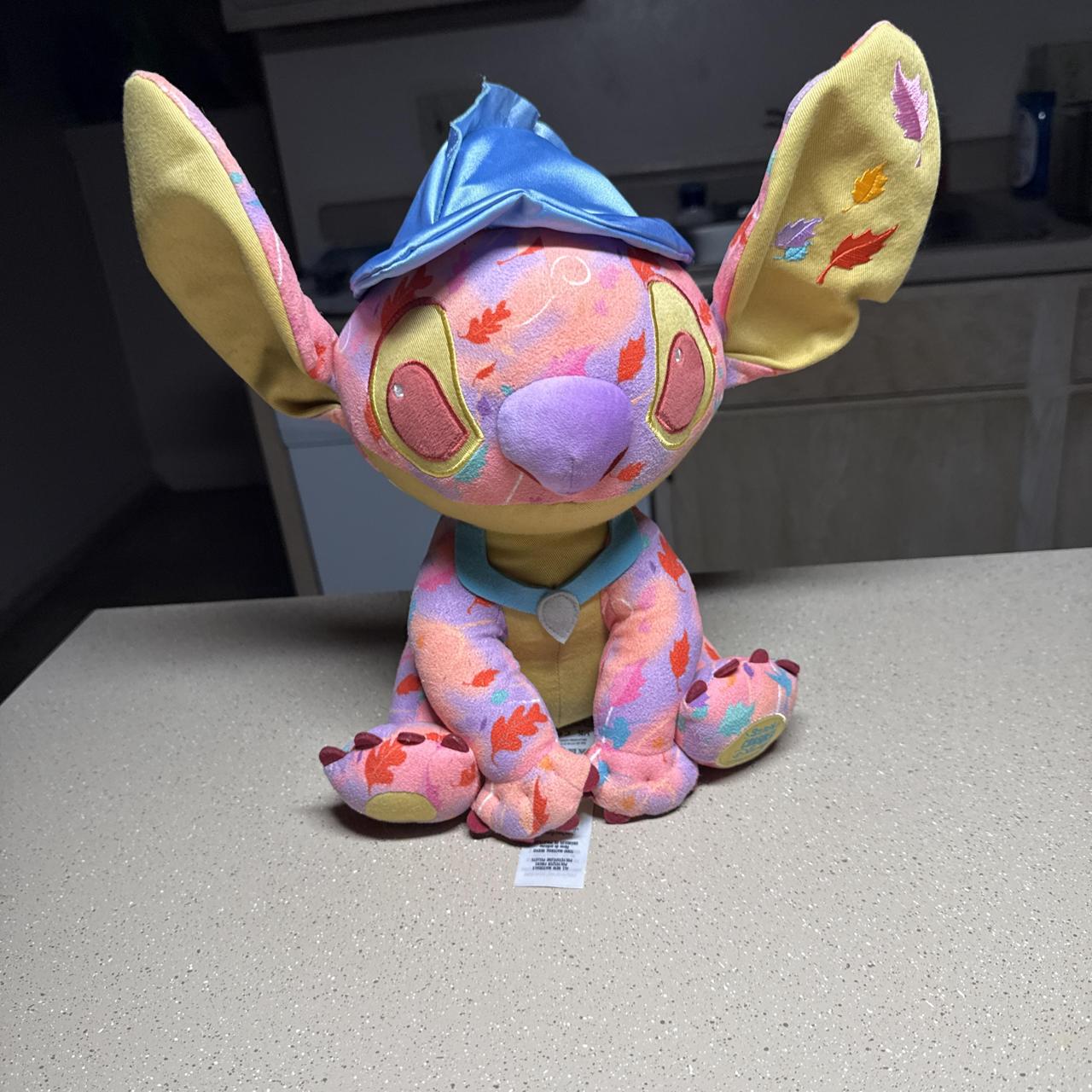 Disney Stitch plush with pink, orange, and purple...